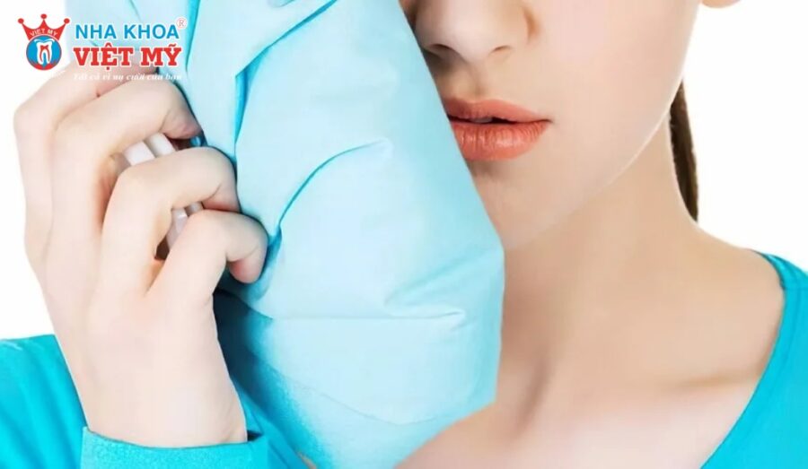 Nước đá chườm ngoài má giúp giảm ê buốt răng tức thì